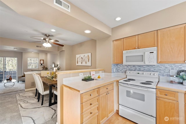 kitchen featuring light brown cabinets, tile countertops, white appliances, and kitchen peninsula