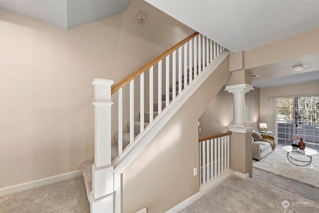 staircase featuring decorative columns and carpet floors