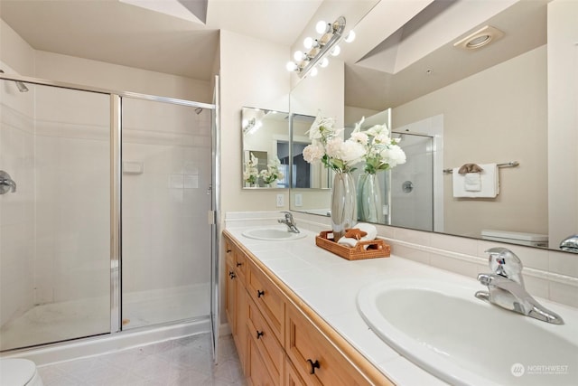 bathroom with a shower with door, vanity, and toilet