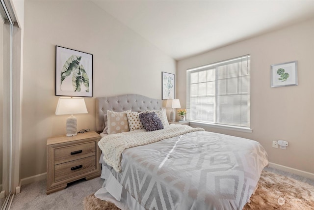 carpeted bedroom featuring lofted ceiling