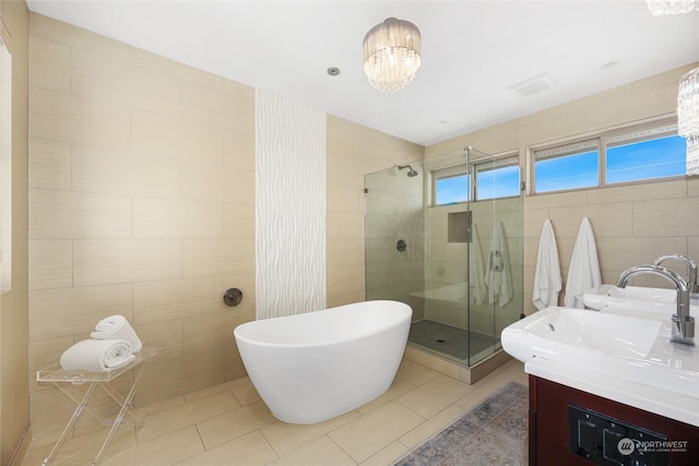 bathroom with a chandelier, tile walls, vanity, independent shower and bath, and tile patterned flooring