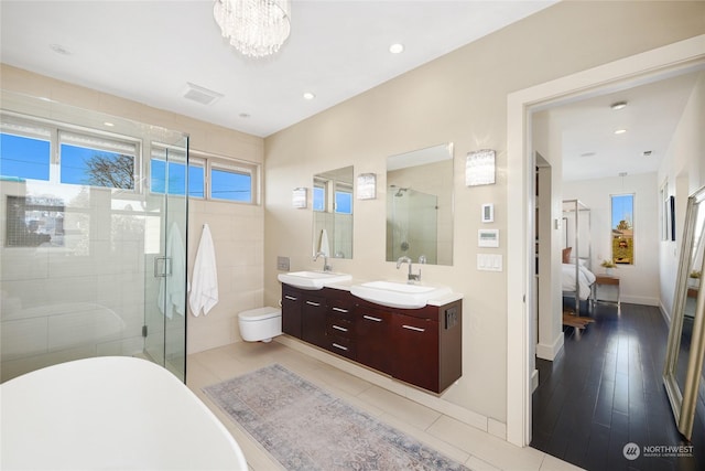 bathroom featuring vanity, a chandelier, and plus walk in shower