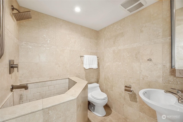 bathroom featuring sink, tile walls, a shower, tile patterned floors, and toilet