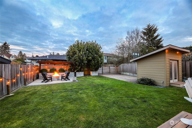 view of yard with an outdoor structure, a patio area, and a fire pit