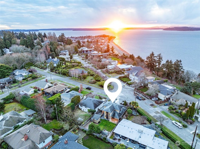 aerial view at dusk featuring a water view