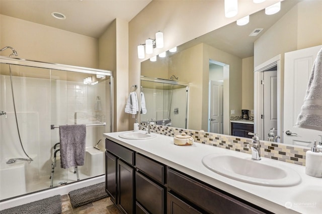 bathroom with an enclosed shower, vanity, and decorative backsplash