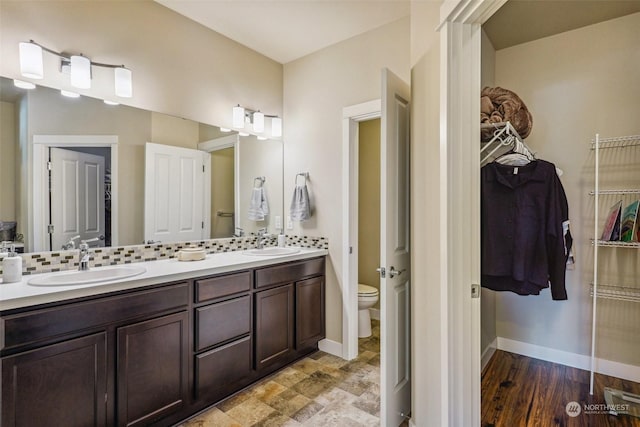 bathroom featuring tasteful backsplash, vanity, and toilet