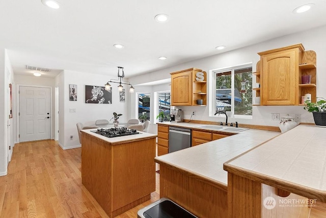 kitchen featuring sink, dishwasher, hanging light fixtures, tile countertops, and kitchen peninsula