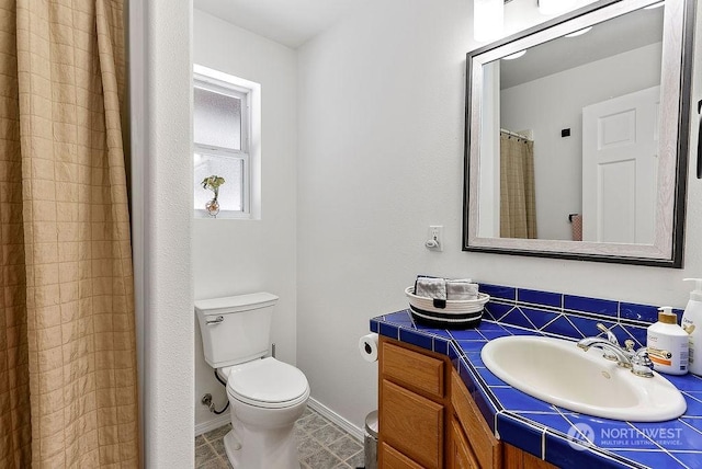 bathroom featuring vanity, toilet, and walk in shower