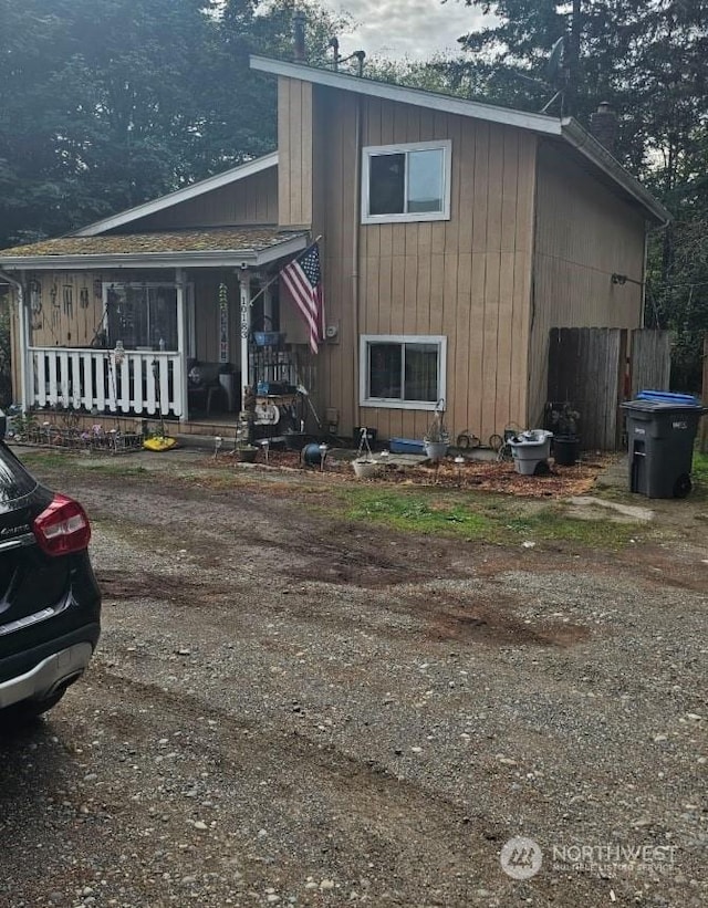 rear view of property featuring covered porch