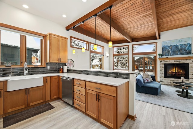 kitchen featuring a wealth of natural light, sink, backsplash, pendant lighting, and kitchen peninsula