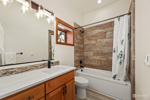 full bathroom featuring hardwood / wood-style floors, vanity, shower / bath combo, toilet, and tasteful backsplash