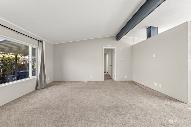 carpeted spare room featuring vaulted ceiling with beams