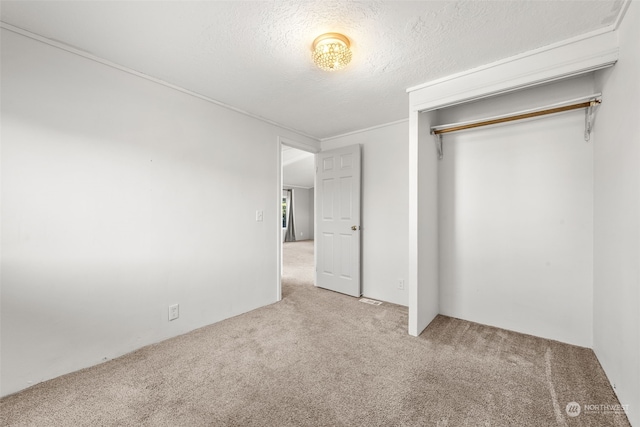 unfurnished bedroom with light carpet, a closet, and a textured ceiling