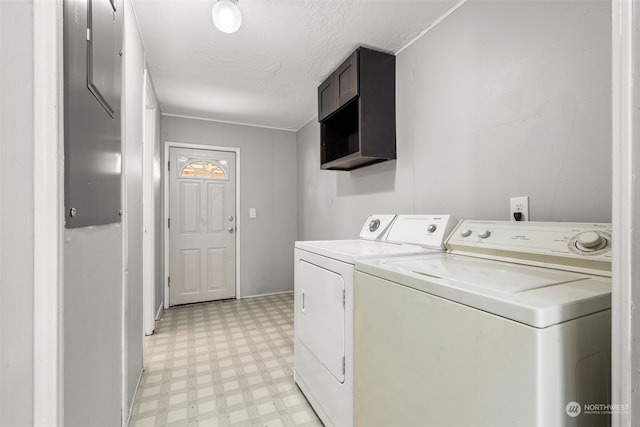 laundry area with washing machine and clothes dryer and a textured ceiling