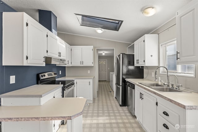 kitchen featuring stainless steel appliances, lofted ceiling, sink, and white cabinets