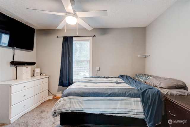 carpeted bedroom with ceiling fan and a textured ceiling