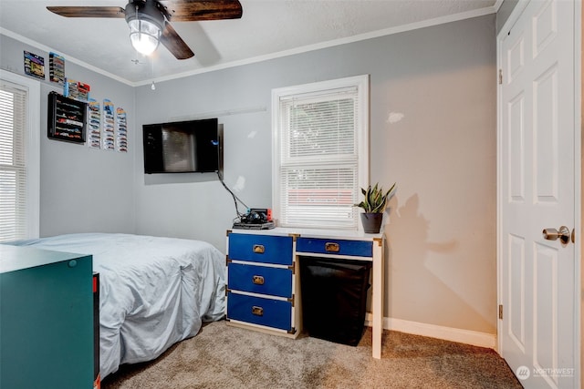 carpeted bedroom with ornamental molding and ceiling fan