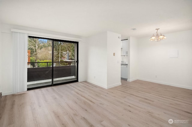 unfurnished room with an inviting chandelier and light hardwood / wood-style flooring