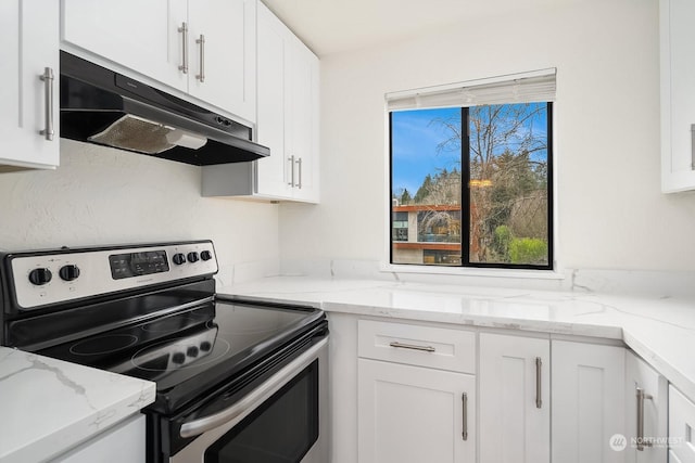 kitchen with white cabinets, light stone counters, and electric stove