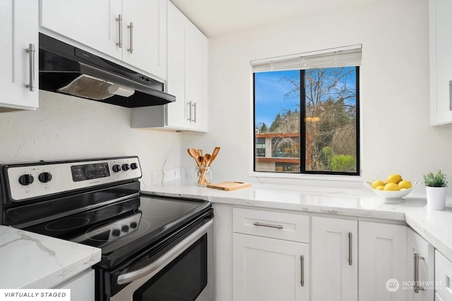 kitchen with light stone countertops, white cabinets, and stainless steel electric range oven