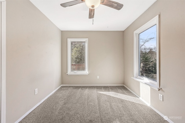 carpeted spare room featuring ceiling fan