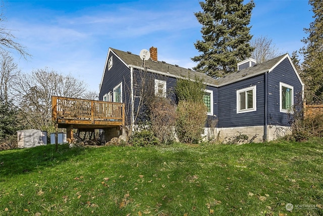 back of property featuring a yard and a deck