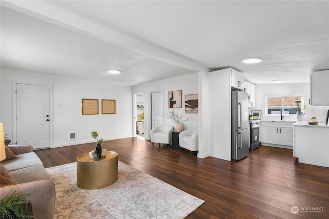 living room with sink and dark wood-type flooring