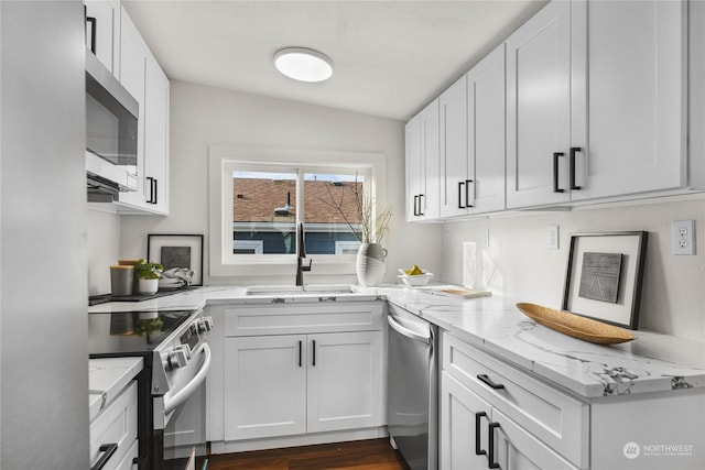 kitchen featuring appliances with stainless steel finishes, light stone countertops, sink, and white cabinets