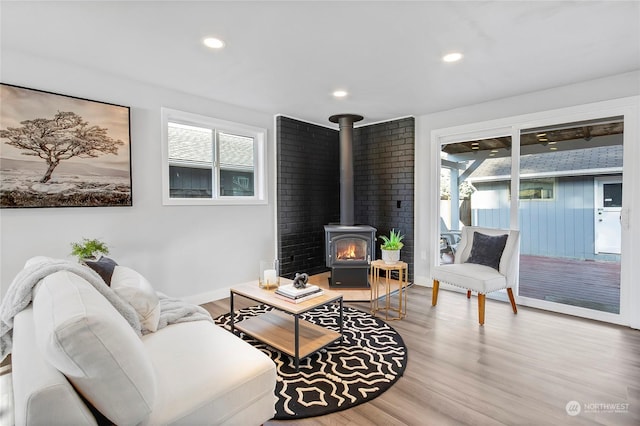 living room with plenty of natural light, a wood stove, and hardwood / wood-style floors