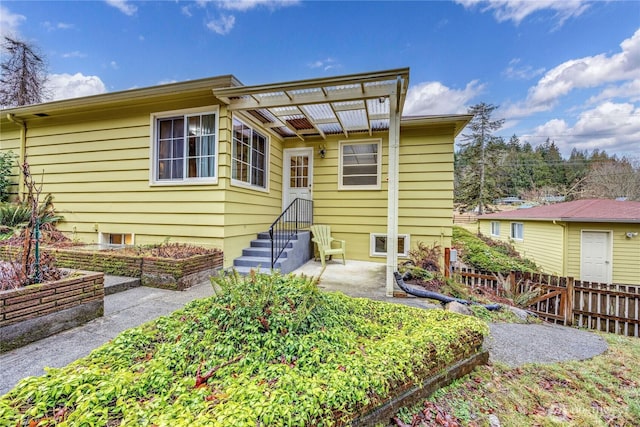 rear view of property featuring a patio area and fence