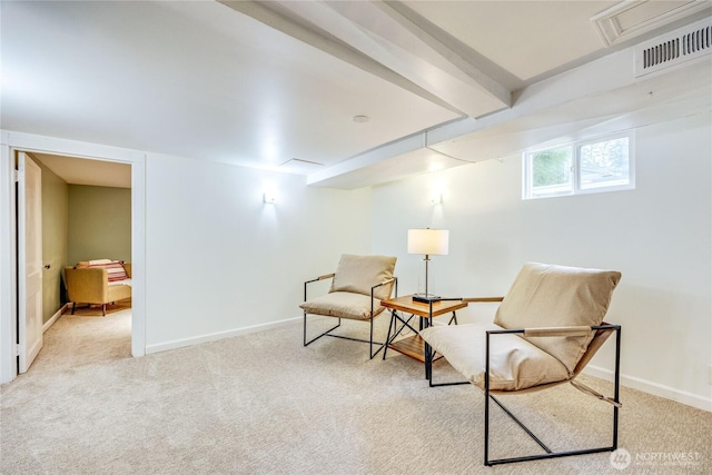 sitting room with light carpet, baseboards, visible vents, and beam ceiling