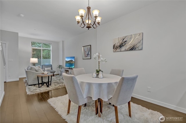 dining area with a chandelier, dark wood-type flooring, and baseboards