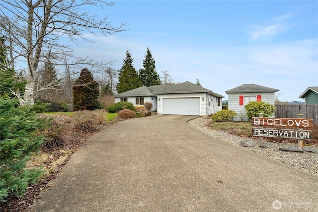 ranch-style home with aphalt driveway, fence, and an attached garage