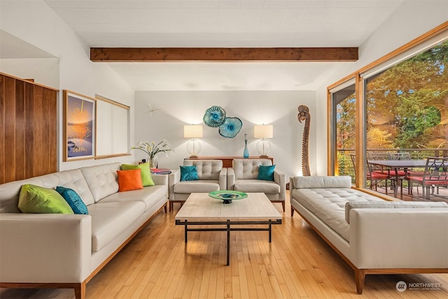 living room featuring beam ceiling and light hardwood / wood-style flooring