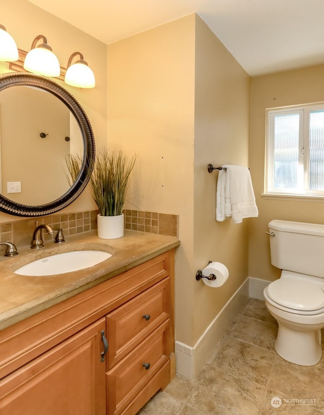 bathroom with vanity, backsplash, and toilet