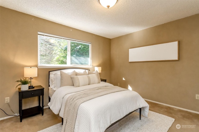 bedroom with light carpet and a textured ceiling