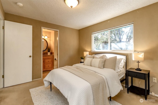 bedroom featuring connected bathroom, light carpet, and a textured ceiling