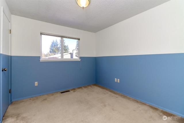 empty room with light carpet and a textured ceiling