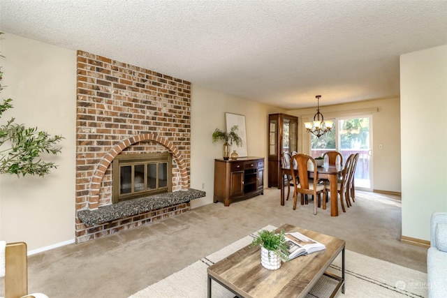 carpeted living room featuring a textured ceiling, a fireplace, and a chandelier