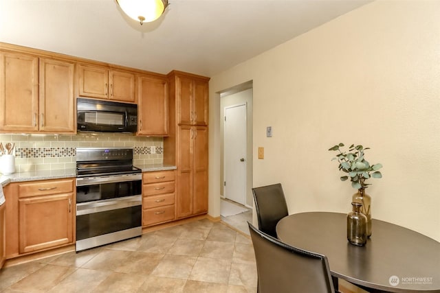 kitchen featuring tasteful backsplash, double oven range, light tile patterned floors, and light stone countertops