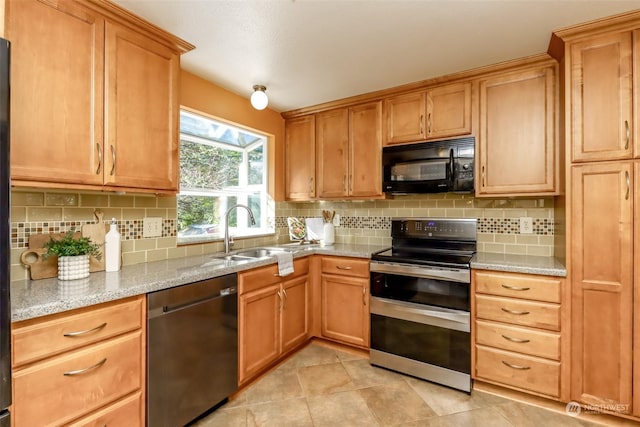 kitchen with light tile patterned flooring, sink, light stone countertops, decorative backsplash, and black appliances