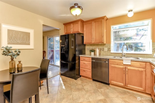 kitchen featuring sink, tasteful backsplash, black refrigerator with ice dispenser, stainless steel dishwasher, and a wealth of natural light