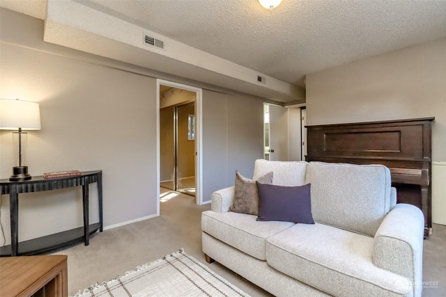 living room featuring light colored carpet and a textured ceiling