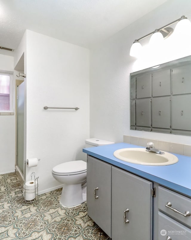 bathroom with vanity, tile patterned floors, a shower, and toilet