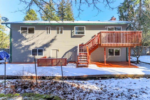 snow covered house featuring a wooden deck