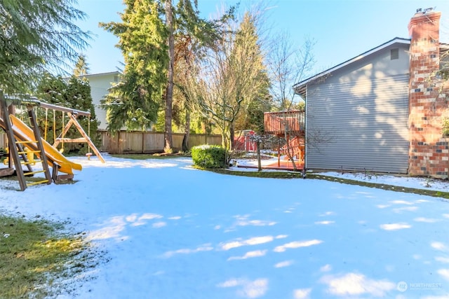 yard covered in snow with a playground