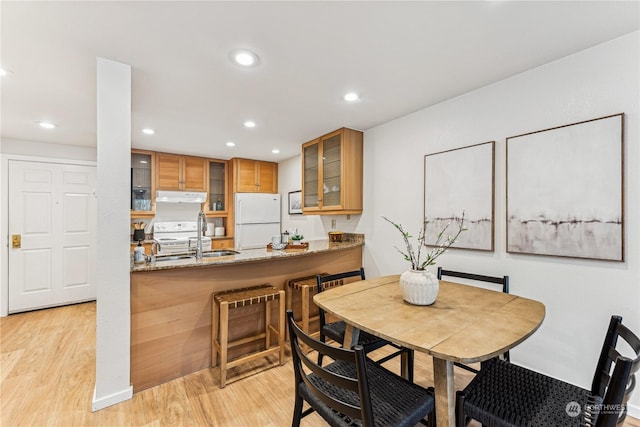 dining area featuring sink and light wood-type flooring