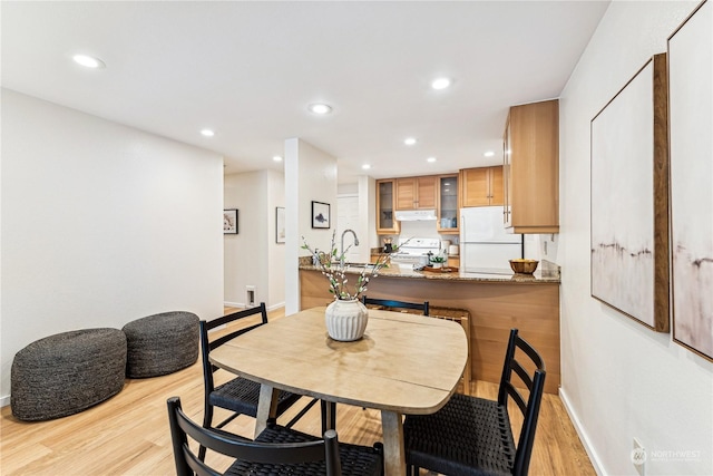 dining room with sink and light hardwood / wood-style flooring