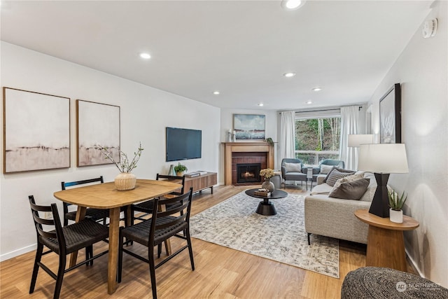 living room with a fireplace and light wood-type flooring